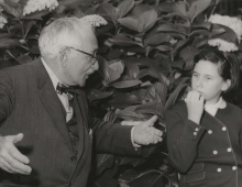 Black and white vintage photo of grandfather talking to granddaughter